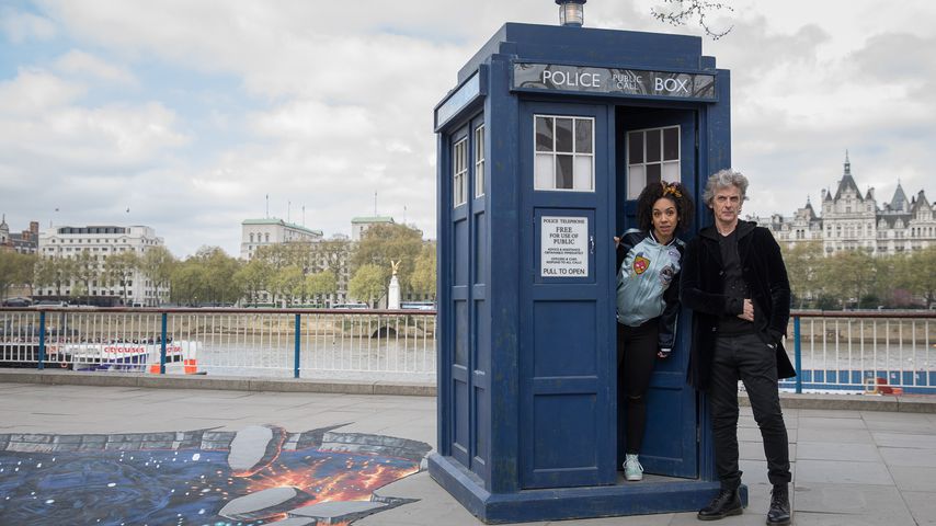"Doctor Who"-Star Peter Capaldi und eine Kollegin vor der Zeitreise-Box