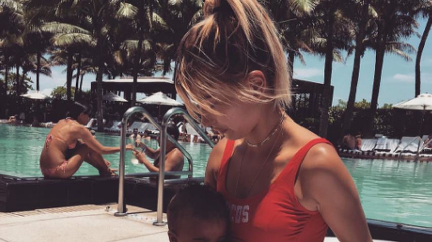 Hailey Baldwin in einem roten Badeanzug an einem Pool