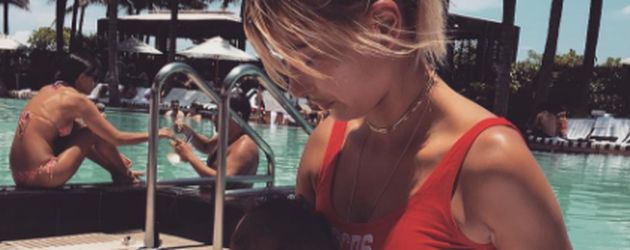 Hailey Baldwin in einem roten Badeanzug an einem Pool Hailey Baldwin in einem roten Badeanzug an einem Pool